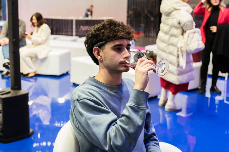 Un ospite indossa il sensore EEG di BrainArt durante la degustazione di un calice di vino.