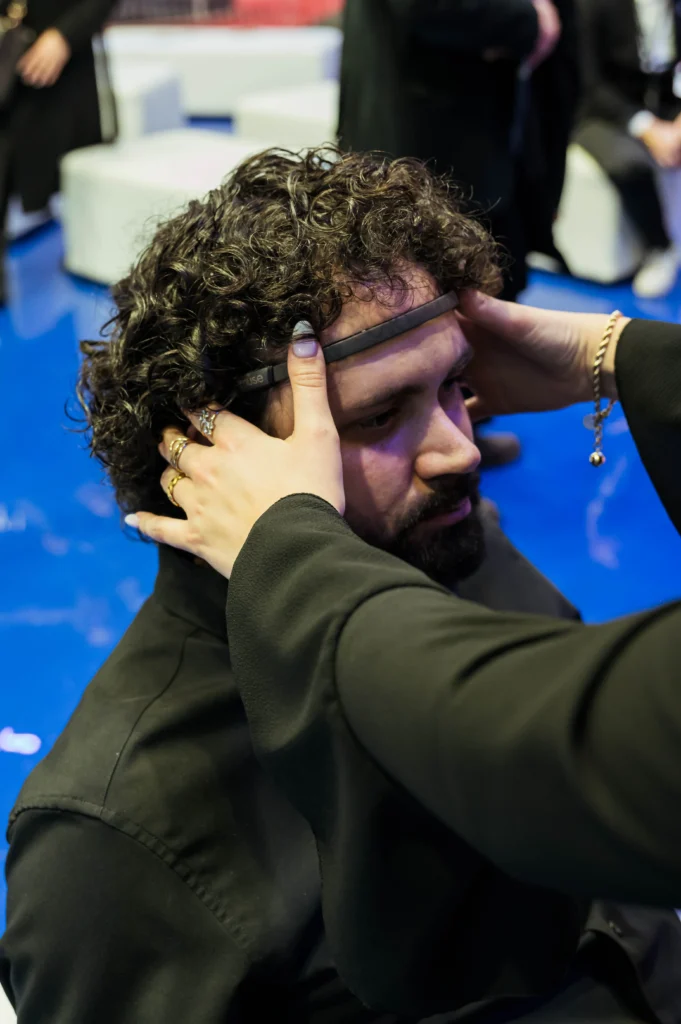 Una operatrice posiziona il sensore EEG di BrainArt sulla fronte di un ospite prima della degustazione.
