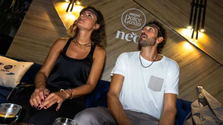 Due ospiti con il sensore EEG in fronte durante l'esperienza BrainArt al lancio di Nescafé Dolce Gusto NEO, con lo sguardo rivolto allo schermo.