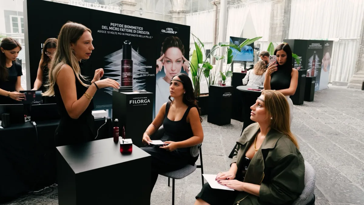 Presentazione della linea Filorga Pro-collagen Micro-growth Factor a due ospiti sedute al banco, con il siero in primo piano