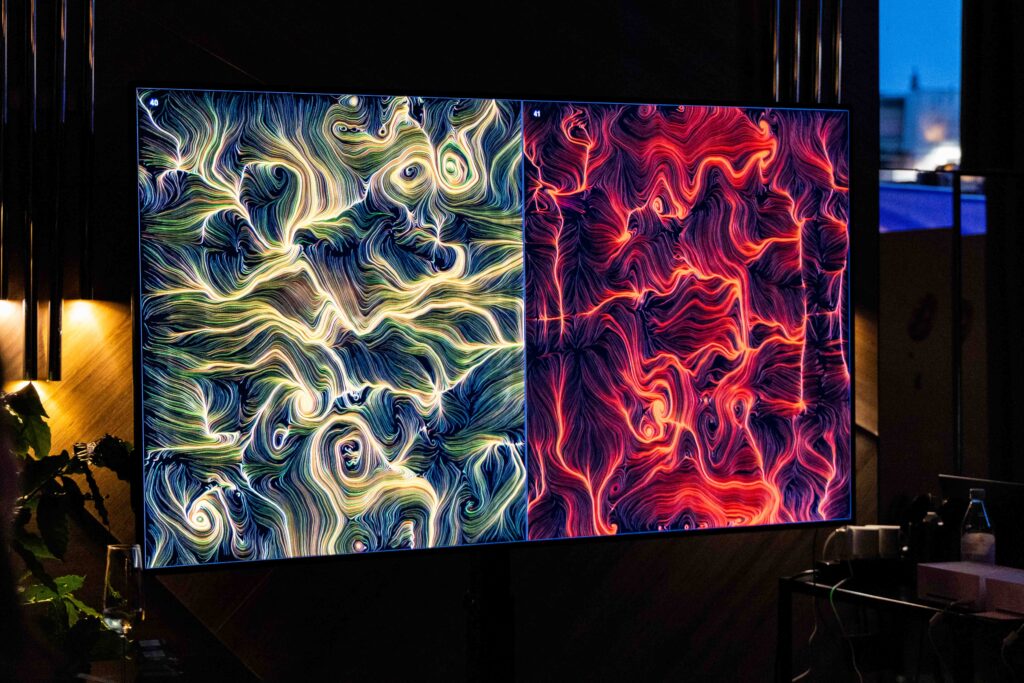 Due opere BrainArt sullo schermo diviso a metà al lancio di Nescafé Dolce Gusto NEO: filamenti verdi e oro a sinistra, rossi e corallo a destra.